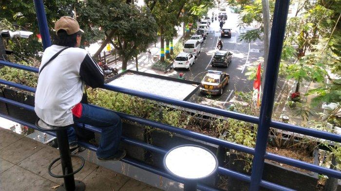 Warga duduk di kursi untuk beristirahat sejenak di jembatan penyeberangan orang (JPO) yang ditanami beragam tanaman hias, di Jalan Wastukencana, Kota Bandung, Jawa Barat, Senin (18/9/2023).