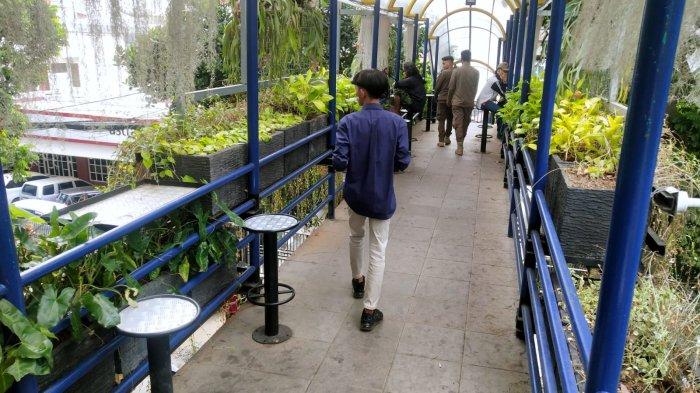 Warga melintas dan sebagian lagi duduk di kursi untuk beristirahat sejenak di jembatan penyeberangan orang (JPO) yang dihiasi beragam tanaman hias, di Jalan Wastukencana, Kota Bandung, Jawa Barat, Senin (18/9/2023).