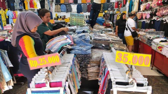 Wisatawan berbelanja pakaian di salah satu toko saat mengunjungi kawasan wisata belanja di Jalan Cihampelas, Kota Bandung, Jawa Barat, Kamis (28/9/2023).