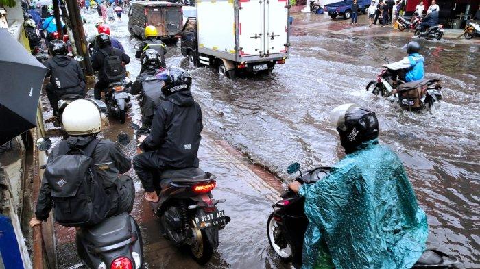 Pengendara sepeda motor memilih menaikan kendaraannya ke trotoar saat melintasi banjir cileuncang yang merendam Jalan Kopo Citarip, Kelurahan Kopo, Kecamatan Bojongloa Kaler, Kota Bandung, Jawa Barat, Selasa (24/10/2023).