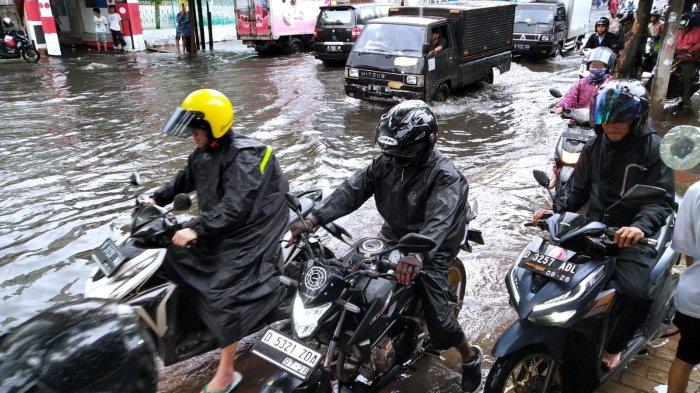 Pengendara sepeda motor memilih menaikan kendaraannya ke trotoar saat melintasi banjir cileuncang yang merendam Jalan Kopo Citarip, Kelurahan Kopo, Kecamatan Bojongloa Kaler, Kota Bandung, Jawa Barat, Selasa (24/10/2023).