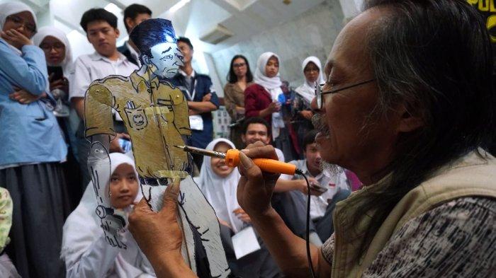 Seniman Muhammad Tavip (Abah Tavip) mempraktikan cara membuat Wayang Tavip di hadapan sejumlah pelajar pada acara workshop di Monumen Perjuangan Rakyat Jawa Barat (Monpera Jabar), Jalan Dipatiukur, Kota Bandung, Jawa Barat, Rabu (1/11/2023).