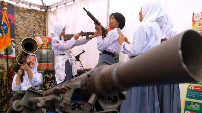 Pelajar mencoba memegang senjata laras panjang dan bazooka yang digunakan pada masa penjajahan koleksi Museum Mandala Wangsit dalam gelaran Museum Monpera Expo di pelataran Moseum Perjuangan Rakyat Jawa Barat (Monpera Jabar), Jalan Dipatiukur, Kota Bandung, Jawa Barat, Kamis (2/11/2023).