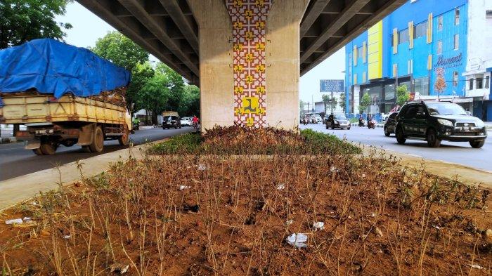Pengguna jalan melewati taman yang tidak terawat di bawah Jalan Layang / Flyover Kopo, Kota Bandung, Jawa Barat, Rabu (8/11/2023).