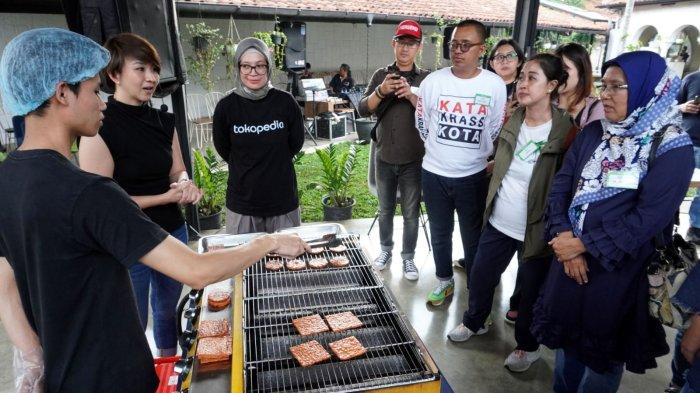 Kepala Divisi Komunikasi Tokopedia, Rizky Juanita Azuz (ketiga dari kiri) bersama sejumlah jurnalis menyaksikan pemilik usaha Dendeng Kukuruyuk, Novi Herawati (kedua dari kiri) mempraktikan cara memanggang dendeng olahan pada kegiatan Media Workshop Tokopedia Bersama UMKM Bandung Dendeng Kukuruyuk di Mr Roastman Experience, Jalan Ciumbuleuit, Kota Bandung, Jawa Barat, Rabu (22/11/2023).