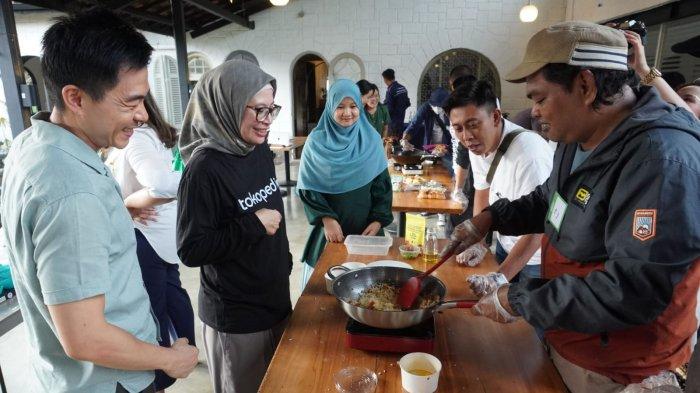Kepala Divisi Komunikasi Tokopedia, Rizky Juanita Azuz (kedua dari kiri) bersama pemilik usaha Dendeng Kukuruyuk, David Perdana Haryadi (kiri) menyaksikan jurnalis membuat nasi goreng dengan taburan dendeng olahan pada kegiatan Media Workshop Tokopedia Bersama UMKM Bandung Dendeng Kukuruyuk di Mr Roastman Experience, Jalan Ciumbuleuit, Kota Bandung, Jawa Barat, Rabu (22/11/2023).
