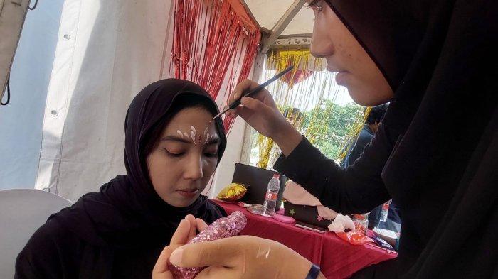 Seorang peserta dirias wajahnya sebelum tampil dalam performance pada gelaran Ganesha Fair: A Spectacle of Magical Talent di Kiara Artha Park, Kota Bandung, Jawa Barat, Sabtu (2/12/2023).