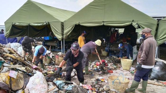 Sejumlah pekerja memindahkan sampah yang baru turun dari truk sampah ke mesin Gibrik Mini untuk dipilah dan dicacah, di Tempat Pengolahan Sampah Terpadu (TPST) Gedebage, Kota Bandung, Jawa Barat, Senin (6/12/2023).