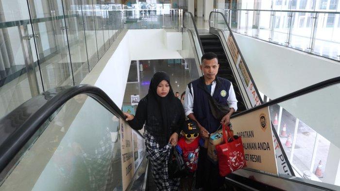 Calon penumpang menuju ke lantai dua untuk membeli tiket bus naik eskalator di Terminal Tipe A Leuwipanjang, Kota Bandung, Jawa Barat, Jumat (8/12/2023).