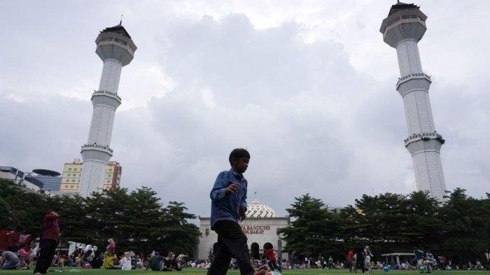 Warga mengisi liburan di lapangan rumput sintetis Taman Alun-alun Kota Bandung, Jawa Barat, Selasa (2/1/2024).