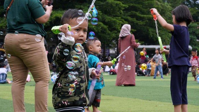Warga mengisi liburan di lapangan rumput sintetis Taman Alun-alun Kota Bandung, Jawa Barat, Selasa (2/1/2024).
