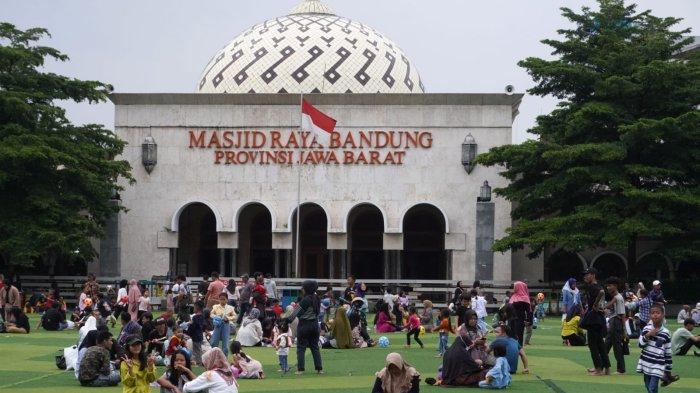 Warga mengisi liburan di lapangan rumput sintetis Taman Alun-alun Kota Bandung, Jawa Barat, Selasa (2/1/2024).