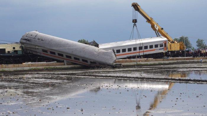 Petugas melakukan evakuasi gerbong kereta api (KA) Lokal Bandung Raya yang terguling akibat tabrakan dengan KA Turangga di Desa Cikuya, Kecamatan Cicalengka, Kabupaten Bandung, Jawa Barat, Jumat (5/1/2024)