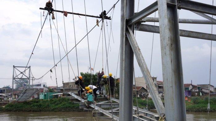 Sejumlah pekerja memasang hanger dan plat untuk bantalan jembatan pada proyek pembangunan Jembatan Roda Dua Rancamanyar, di Desa Rancamanyar, Kecamatan Baleendah, Kabupaten Bandung, Jawa Barat, Kamis (11/1/2024).