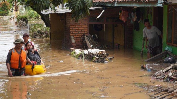 Petugas mengevakuasi warga yang rumahnya terendam air dan material sampah di sekitar lokasi tanggul Sungai Cigede yang jebol, di Kampung Lamajang Peuntas, Desa Citeureup, Kecamatan Dayeuhkolot, Kabupaten Bandung, Jawa Barat, Jumat (12/1/2024).