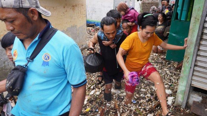 Warga mengungsi meninggalkan rumahnya yang terendam air dan material sampah di sekitar lokasi tanggul Sungai Cigede yang jebol, di Kampung Lamajang Peuntas, Desa Citeureup, Kecamatan Dayeuhkolot, Kabupaten Bandung, Jawa Barat, Jumat (12/1/2024).