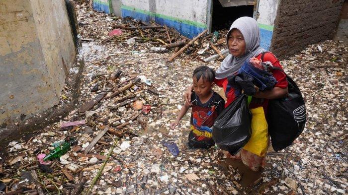 Warga mengungsi meninggalkan rumahnya yang terendam air dan material sampah di sekitar lokasi tanggul Sungai Cigede yang jebol, di Kampung Lamajang Peuntas, Desa Citeureup, Kecamatan Dayeuhkolot, Kabupaten Bandung, Jawa Barat, Jumat (12/1/2024).