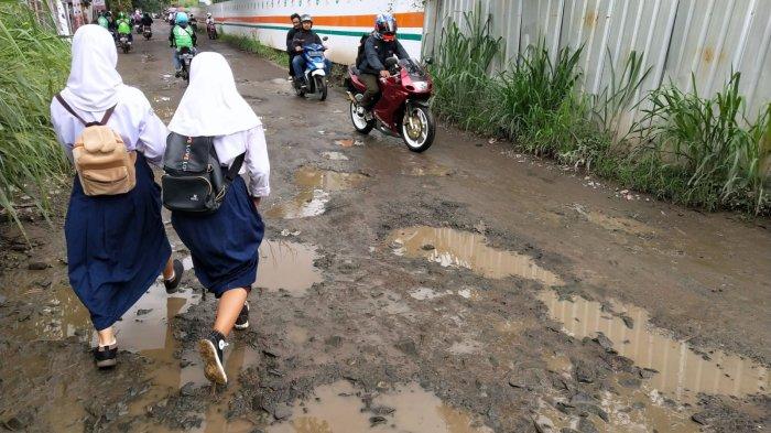 Pengguna jalan melintasi jalan rusak berkubang air di Jalan Radio Palasari, Desa Citeureup, Kecamatan Dayeuhkolot, Kabupaten Bandung, Jawa Barat, Selasa (23/1/2024).