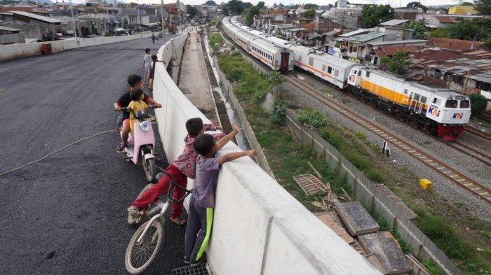 Sejumlah anak melihat kereta api (KA) yang sedang melintas dari Flyover Ciroyom yang pembangunannya sudah rampung di wilayah Kecamatan Andir dan Cicendo, Kota Bandung, Jawa Barat, Jumat (2/2/2024).