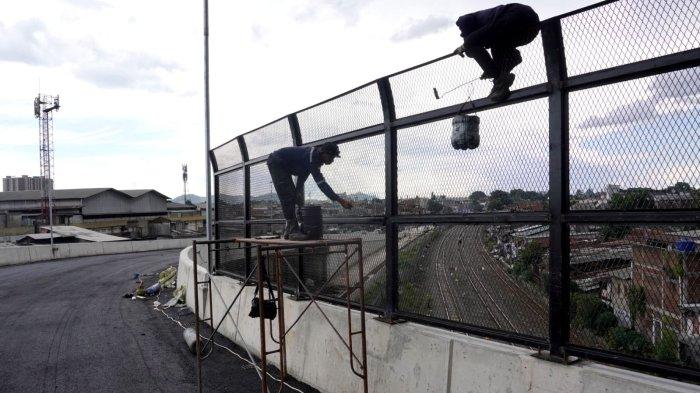 Dua orang pekerja mengecat pagar pengaman di bagian atas Flyover Ciroyom yang pembangunannya sudah rampung di wilayah Kecamatan Andir dan Cicendo, Kota Bandung, Jawa Barat, Jumat (2/2/2024).