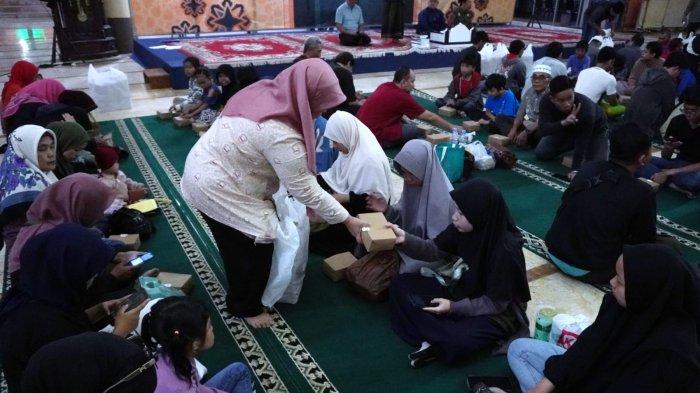 Petugas membagikan paket takjil kepada warga dalam buka puasa bersama di Masjid Raya Bandung Provinsi Jawa Barat, Jalan Asia Afrika, Kota Bandung, Jawa Barat, Selasa (12/3/2024).