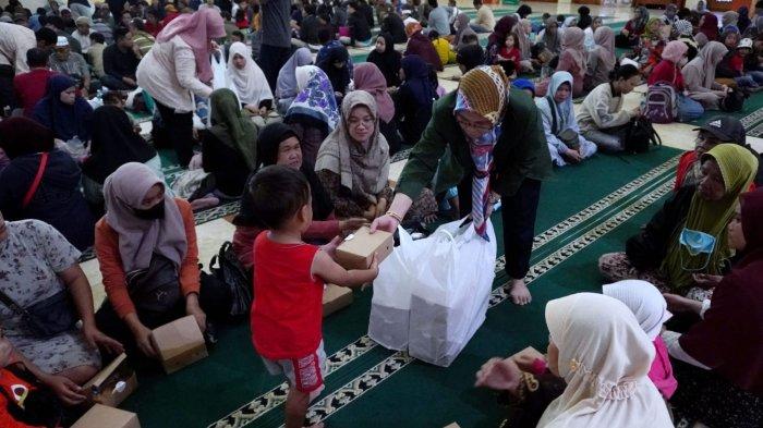 Petugas membagikan paket takjil kepada warga dalam buka puasa bersama di Masjid Raya Bandung Provinsi Jawa Barat, Jalan Asia Afrika, Kota Bandung, Jawa Barat, Selasa (12/3/2024).