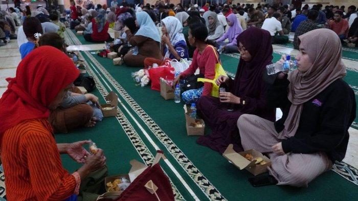 Warga menikmati makanan dan minuman dari paket takjil yang dibagikan saat waktu berbuka puasa tiba di Masjid Raya Bandung Provinsi Jawa Barat, Jalan Asia Afrika, Kota Bandung, Jawa Barat, Selasa (12/3/2024).