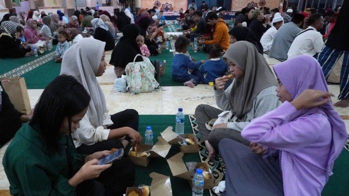 Warga menikmati makanan dan minuman dari paket takjil yang dibagikan saat waktu berbuka puasa tiba di Masjid Raya Bandung Provinsi Jawa Barat, Jalan Asia Afrika, Kota Bandung, Jawa Barat, Selasa (12/3/2024).