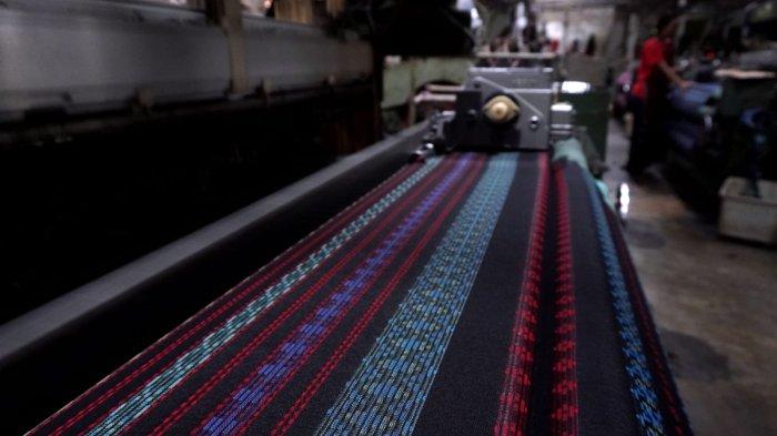 Pekerja menyelesaikan proses pembuatan kain tenun untuk sarung menggunakan mesin Rapier di Pabrik Jaya Mukti, Desa Sinarsari, Kecamatan Majalaya, Kabupaten Bandung, Jawa Barat, Sabtu (23/3/2024).