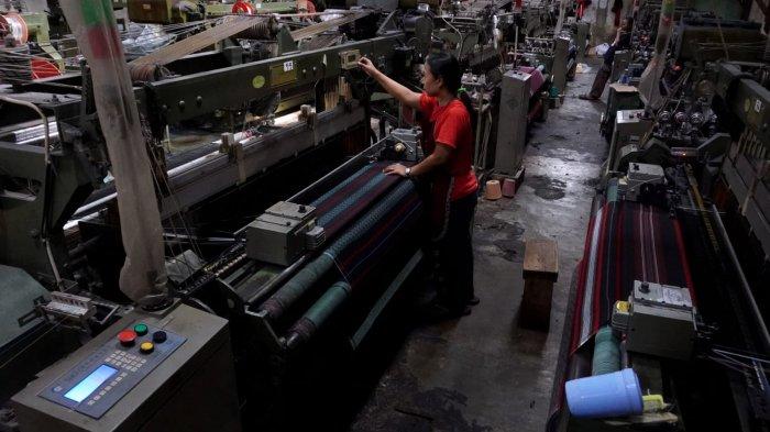 Pekerja menyelesaikan proses pembuatan kain tenun untuk sarung menggunakan mesin Rapier di Pabrik Jaya Mukti, Desa Sinarsari, Kecamatan Majalaya, Kabupaten Bandung, Jawa Barat, Sabtu (23/3/2024).