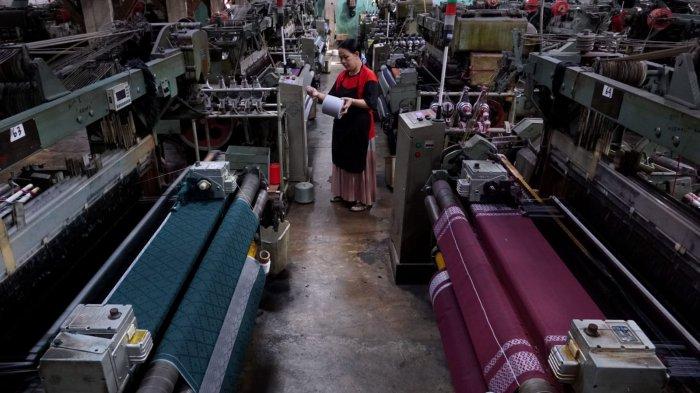 Pekerja menyelesaikan proses pembuatan kain tenun untuk sarung menggunakan mesin Rapier di Pabrik Jaya Mukti, Desa Sinarsari, Kecamatan Majalaya, Kabupaten Bandung, Jawa Barat, Sabtu (23/3/2024).