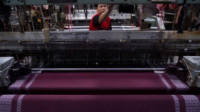 Pekerja menyelesaikan proses pembuatan kain tenun untuk sarung menggunakan mesin Rapier di Pabrik Jaya Mukti, Desa Sinarsari, Kecamatan Majalaya, Kabupaten Bandung, Jawa Barat, Sabtu (23/3/2024).