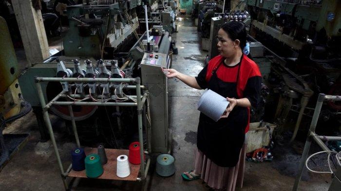 Pekerja menyelesaikan proses pembuatan kain tenun untuk sarung menggunakan mesin Rapier di Pabrik Jaya Mukti, Desa Sinarsari, Kecamatan Majalaya, Kabupaten Bandung, Jawa Barat, Sabtu (23/3/2024).