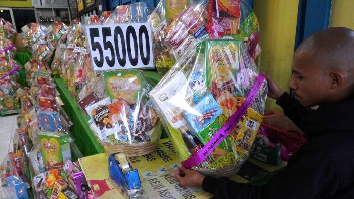 Pelayan toko memasang pita bertuliskan 