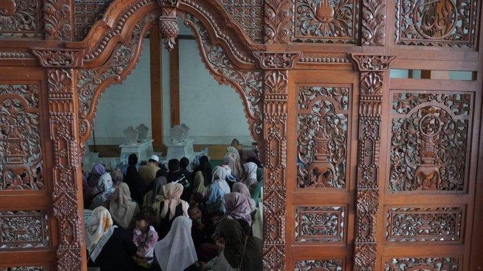 Wisatawan berdoa saat berziarah di makam Mama Eyang Cibaduyut, KH RD Muhammad Zarkasyi, di Jalan Cibaduyut Raya, Gang Pesantren, Kelurahan Cibaduyut, Kecamatan Bojongloa Kidul, Kota Bandung, Jawa Barat, Sabtu (27/4/2024).