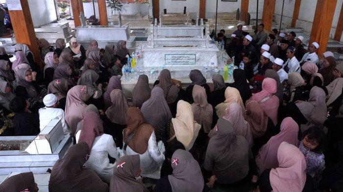 Wisatawan berdoa saat berziarah di makam Mama Eyang Cibaduyut, KH RD Muhammad Zarkasyi, di Jalan Cibaduyut Raya, Gang Pesantren, Kelurahan Cibaduyut, Kecamatan Bojongloa Kidul, Kota Bandung, Jawa Barat, Sabtu (27/4/2024).