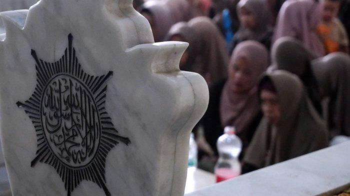Wisatawan berdoa saat berziarah di makam Mama Eyang Cibaduyut, KH RD Muhammad Zarkasyi, di Jalan Cibaduyut Raya, Gang Pesantren, Kelurahan Cibaduyut, Kecamatan Bojongloa Kidul, Kota Bandung, Jawa Barat, Sabtu (27/4/2024).