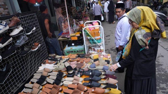 Wisatawan berbelanja sandal di sekitar kompleks pemakaman seusai berziarah di makam Mama Eyang Cibaduyut, KH RD Muhammad Zarkasyi, di Jalan Cibaduyut Raya, Gang Pesantren, Kelurahan Cibaduyut, Kecamatan Bojongloa Kidul, Kota Bandung, Jawa Barat, Sabtu (27/4/2024).