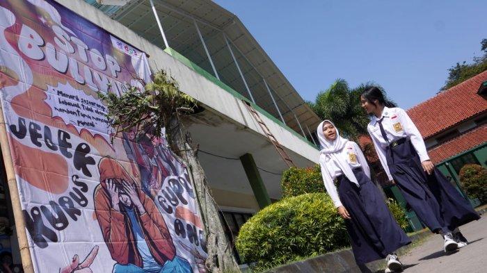 Pelajar SMP melintasi baliho Stop Bullying saat akan mengikuti acara Sosialisasi Pencegahan Kekerasan Terhadap Anak di Lingkungan Satuan Pendidikan, di aula SMP Negeri 2, Jalan Sumatera, Kota Bandung, Jawa Barat, (6/5/2024).
