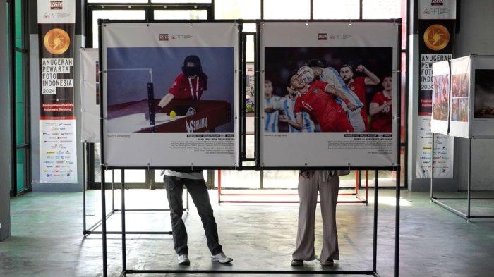 Pengunjung mengamati karya foto yang dipajang pada pameran Anugerah Pewarta Foto Indonesia (APFI) 2024 di Bandung Creative Hub, Jalan Laswi, Kota Bandung, Jawa Barat, Selasa (7/5/2024).