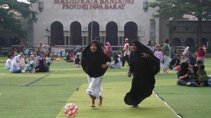 Pengunjung bermain bola di lapangan rumput sintetis Taman Alun-Alun Kota Bandung, Jawa Barat, Kamis (9/5/2024).