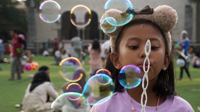 Anak-Anak bermain gelembung sabun atau bubbles di lapangan rumput sintetis Taman Alun-Alun Kota Bandung, Jawa Barat, Kamis (9/5/2024).