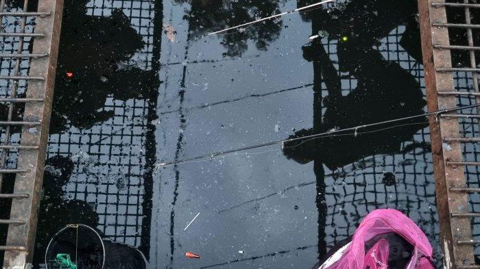 Warga memancing ikan lele di selokan yang membelah Jalan Leuwipanjang, Kota Bandung, Jawa Barat, Kamis (9/5/2024).