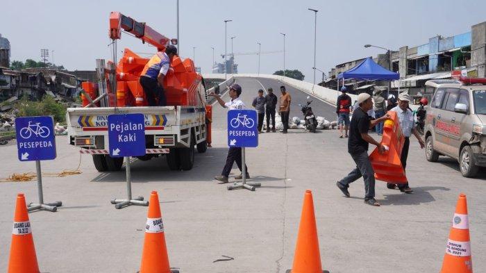 Petugas Dishub Kota Bandung memasang water barrier atau pembatas jalan menggantikan kayu, meja dan spanduk yang sebelumnya dipasang oleh warga menutup akses jalan ke Flyover Ciroyom di Kelurahan Ciroyom, Kecamatan Andir, Kota Bandung, Jawa Barat, Senin (20/5/2024).