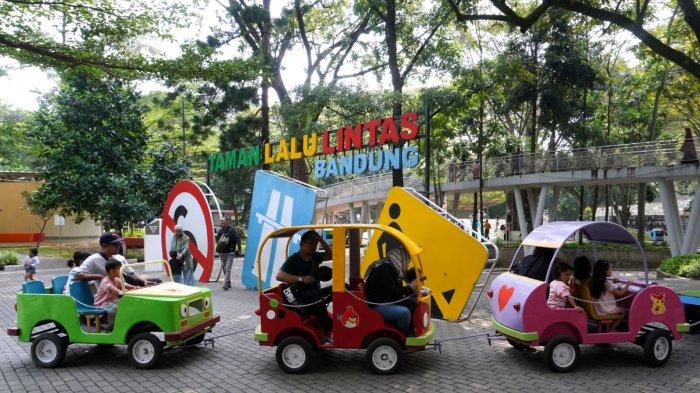 Pengunjung naik kereta mobil saat berwisata di Taman Lalu Lintas Ade Irma Suryani Nasution, Kota Bandung, Jawa Barat, Kamis (23/5/2024).