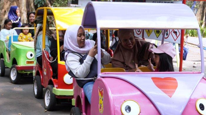 Pengunjung naik kereta mobil saat berwisata di Taman Lalu Lintas Ade Irma Suryani Nasution, Kota Bandung, Jawa Barat, Kamis (23/5/2024).