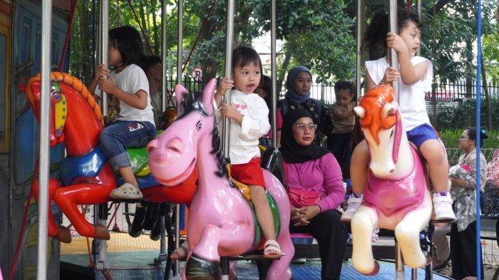 Pengunjung naik korsel saat berwisata di Taman Lalu Lintas Ade Irma Suryani Nasution, Kota Bandung, Jawa Barat, Kamis (23/5/2024).