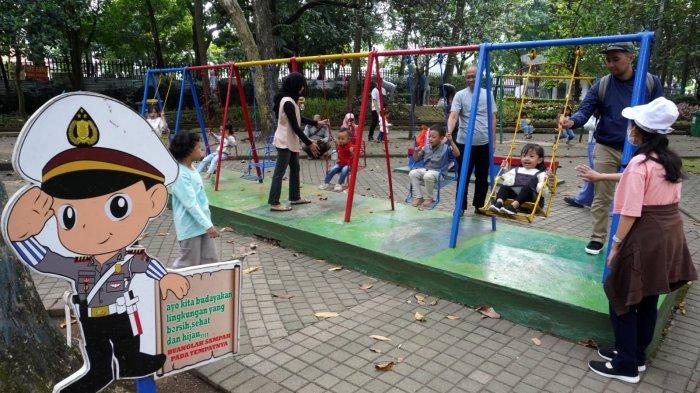 Sejumlah anak kecil bermain ayunan didampingi orang tuanya saat berwisata di Taman Lalu Lintas Ade Irma Suryani Nasution, Kota Bandung, Jawa Barat, Kamis (23/5/2024).