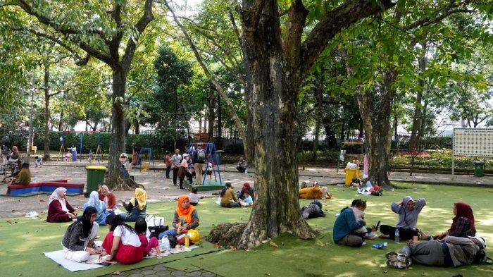 Pengunjung bersantai sambil menikmati makanan saat berwisata di Taman Lalu Lintas Ade Irma Suryani Nasution, Kota Bandung, Jawa Barat, Kamis (23/5/2024).