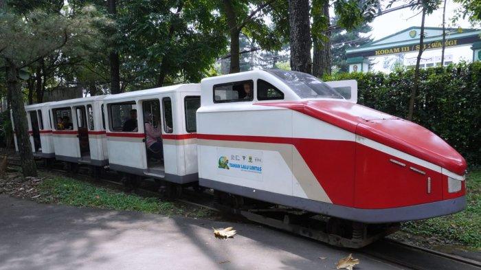 Pengunjung naik kereta api saat berwisata di Taman Lalu Lintas Ade Irma Suryani Nasution, Kota Bandung, Jawa Barat, Kamis (23/5/2024).
